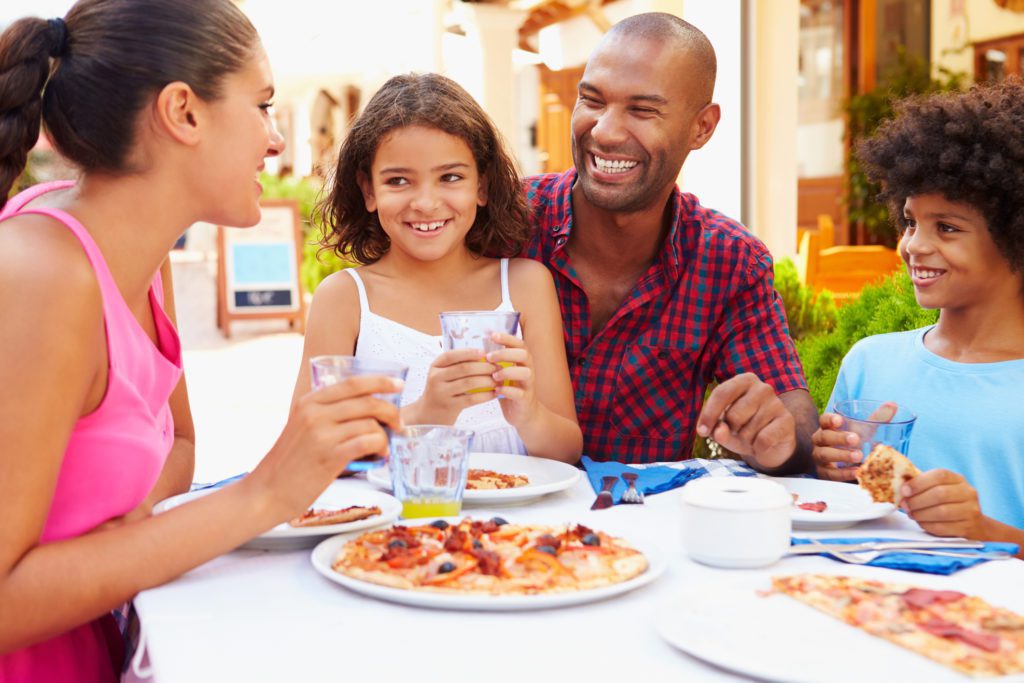 Family eating outside at one of the restaurants at Broadway at the Beach.