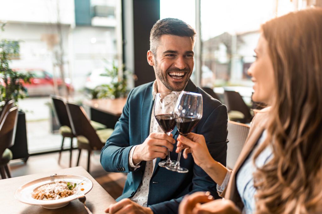 Happy couple drinking red wine at a restaurant during spring break in Myrtle Beach