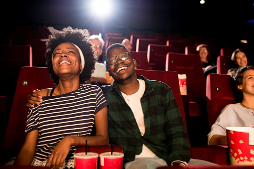 African-American couple on a date watching a movie at the cinema