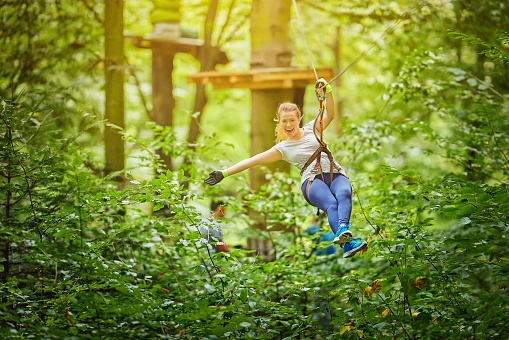 Woman ziplining through the trees