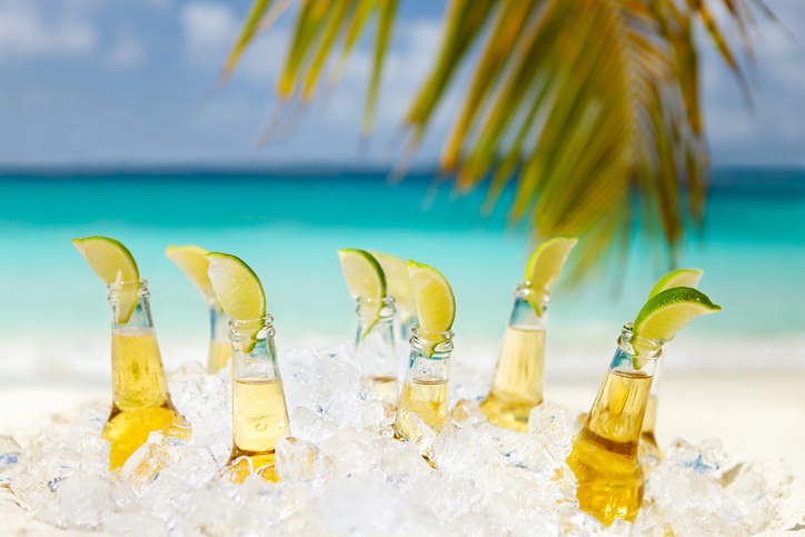 Beers with limes under a palm tree on a beach