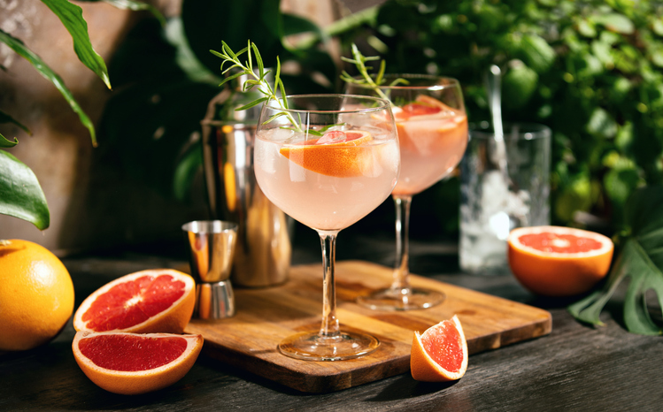 Pink grapefruit and rosemary gin cocktail served in prepared gin cocktail glass on a myrtle beach bar