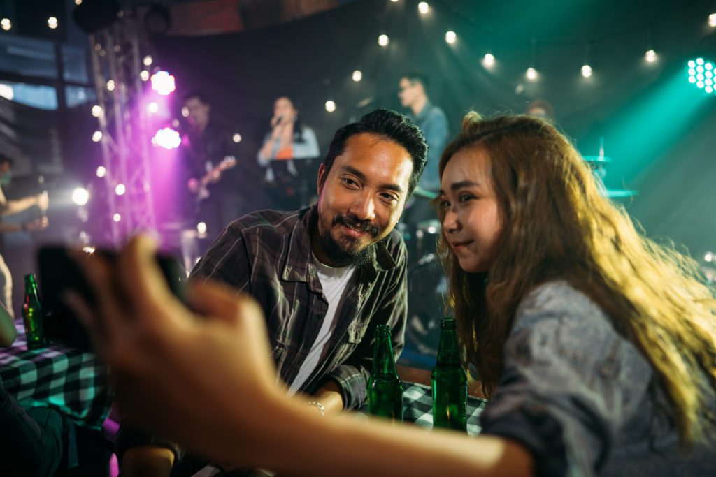A father and daughter taking a moment to take a picture while having a fun time at one of the many local bands at the marshwalk. 