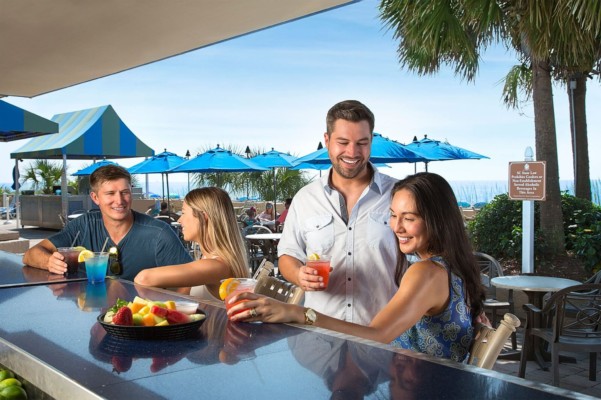 couples enjoying drinks at pool bar
